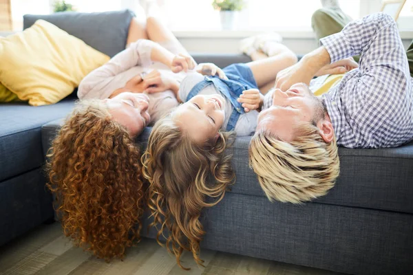 幸福的年轻家庭三个组成 由父亲 母亲和女儿在家里的沙发放松 — 图库照片