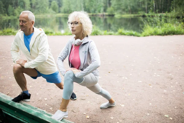 Pareja Madura Energética Ropa Deportiva Ejercitando Por Banco Parque Con — Foto de Stock