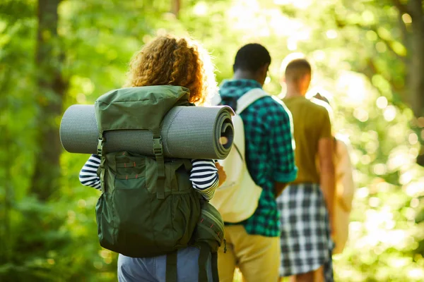 キャンプに歩きながら自然環境の中を歩く若いキャンパーのリアビュー — ストック写真