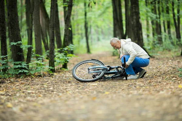 Senior Idrotts Utövare Huk Över Sin Cykel Marken Eller Liggande — Stockfoto