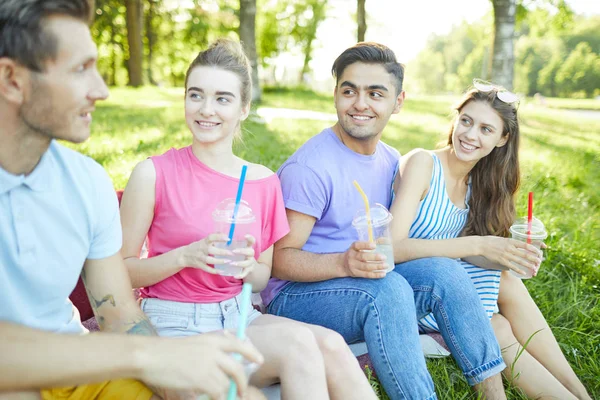 Grupo Jóvenes Amigos Con Bebidas Escuchando Chico Durante Reunión Aire —  Fotos de Stock