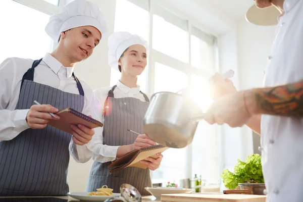 Positieve Nieuwsgierige Studenten Chefs Hoeden Schort Maken Notities Terwijl Het — Stockfoto