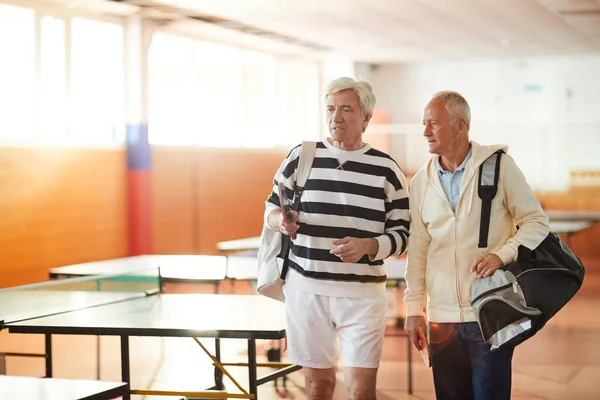 Twee Senior Sportsmen Met Tassen Die Praten Tijdens Het Verhuizen — Stockfoto