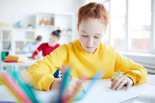 Ragazzina Concentrandosi Sul Disegno Individuale Lezione Sullo Sfondo Dei Suoi — Foto Stock