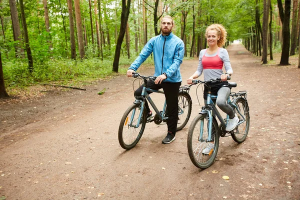 两个骑着自行车的快乐的年轻自行车站在森林路上 训练或冷静下来 — 图库照片