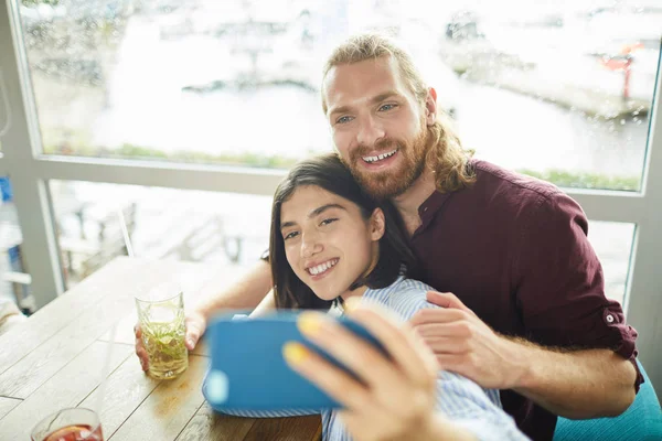 Jovem Casal Alegre Fazendo Selfie Enquanto Sentado Mesa Café Tomando — Fotografia de Stock