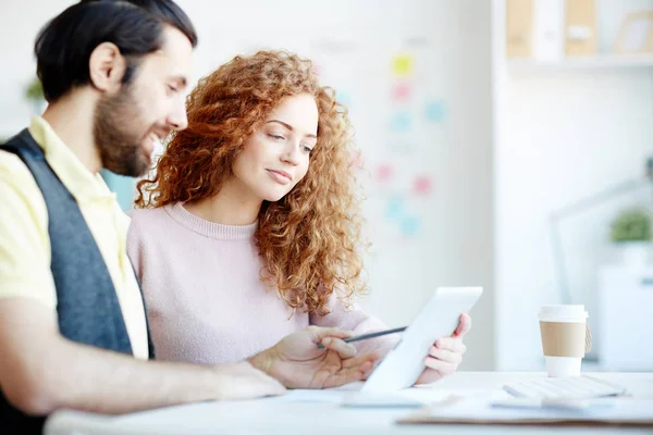 Young Curly Businesswoman Looking Touchpad Display While Her Colleague Explaining — Stock Photo, Image