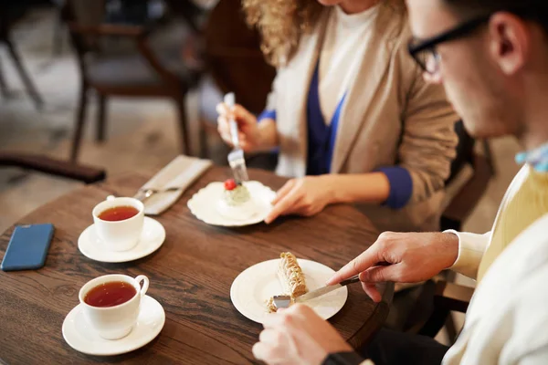 ガールフレンドとカフェテリアでティータイムを過ごしながら プレートからデザートの一部を取る男 — ストック写真