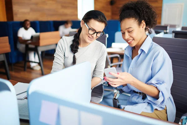 Joven Mujer Negocios Sonriente Sentada Junto Con Colega Mostrando Algo — Foto de Stock