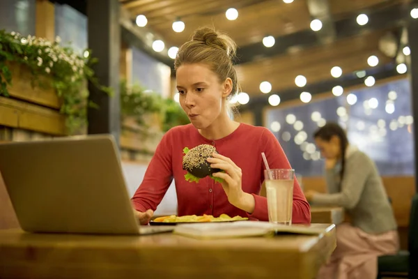 Kız Net Bilgi Ararken Üniversite Kafede Çizburger Patates Kızartması Yiyor — Stok fotoğraf