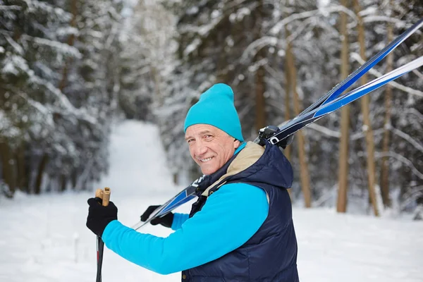 Happy Åldern Sportsman Transporterar Skidutrustning Medan Flyttar Till Skogen Vinterdag — Stockfoto