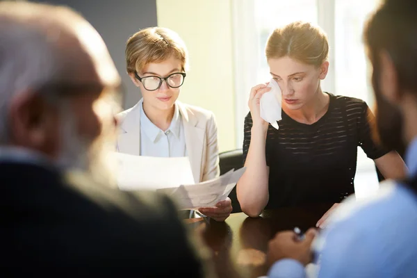 Oppskaket Ung Forretningskvinne Som Tørker Tårene Mens Hun Ser Papirer – stockfoto