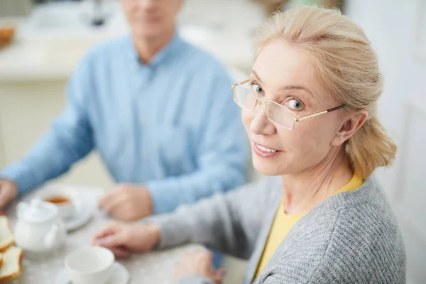 Blonde Vrouw Bril Camera Kijken Terwijl Ontbijt Met Man Thuis — Stockfoto