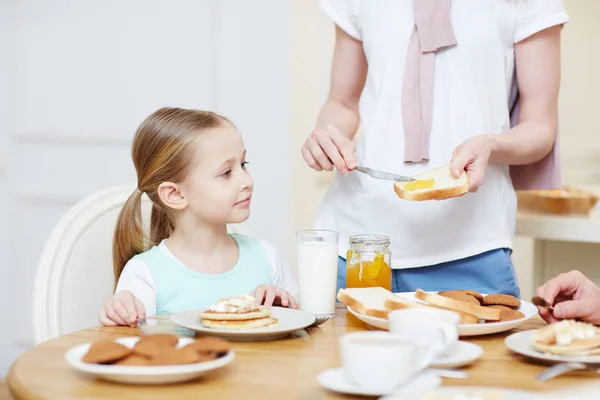 Konzentrierte Hübsche Tochter Mit Pferdeschwänzen Sitzt Esstisch Voller Desserts Und — Stockfoto