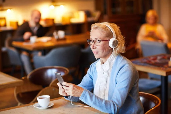 Mujer Rubia Envejecida Escuchando Música Auriculares Eligiendo Pista Lista Reproducción — Foto de Stock