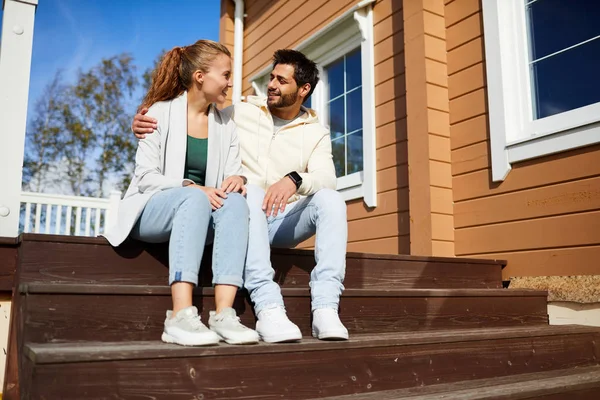 Casal Afetuoso Sentado Escada Madeira Por Sua Nova Casa Conversando — Fotografia de Stock