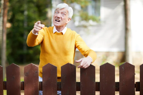 Wütender Senior Gelben Pullover Steht Zaun Und Zeigt Mit Genervtem — Stockfoto