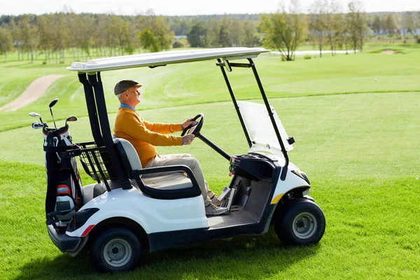 Contemporary Aged Man Driving Golf Car Vast Green Field While — Stock Photo, Image