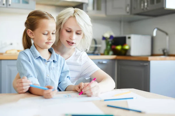 Młoda Kobieta Rysuje Coś Kredką Papierze Uczy Córeczkę Domu — Zdjęcie stockowe