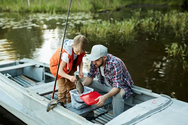 Маленький Мальчик Выбрасывает Большую Рыбу Пластиковое Ведро Контейнер Время Рыбалки — стоковое фото