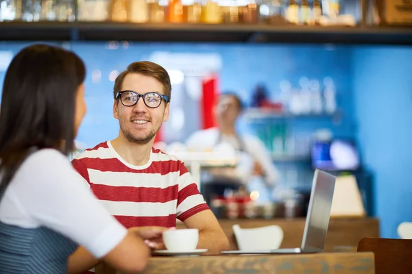 カフェでコーヒーを楽しみながら休みの日に話をした若い男 — ストック写真