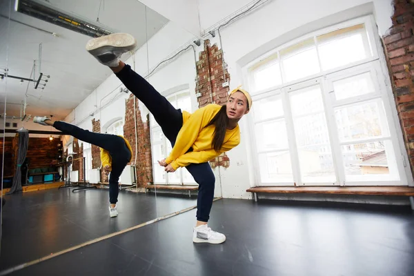 Joven Bailarina Hip Hop Ropa Deportiva Estirando Pierna Derecha Mientras —  Fotos de Stock