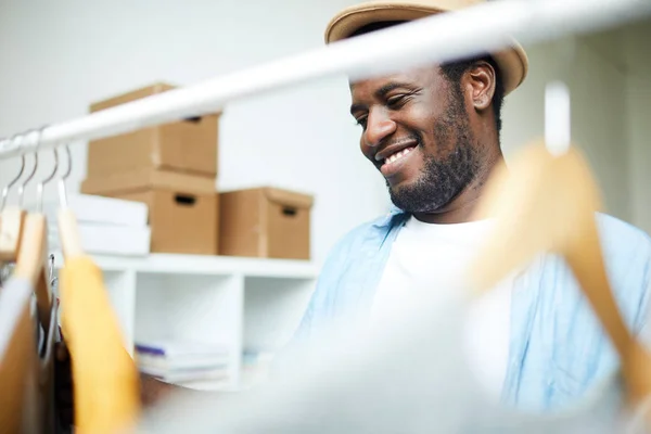 非洲微笑的造型师站在货架附近 挑选衣服 — 图库照片