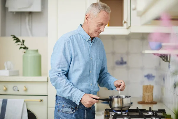 Uomo Anziano Mescolando Qualcosa Padella Mentre Piedi Fornello Gas Cottura — Foto Stock