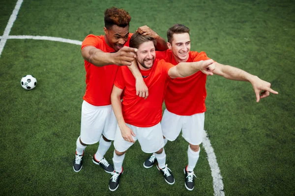 Tres Jóvenes Futbolistas Felices Parados Campo Verde Riendo Apuntando Hacia — Foto de Stock