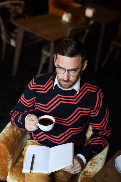 Ung Seriös Man Med Öppen Anteckningsbok Och Kopp Svart Kaffe — Stockfoto