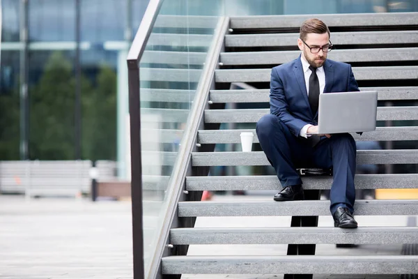 Joven Hombre Con Estilo Vestido Negocios Gafas Mirando Portátil Sentado — Foto de Stock