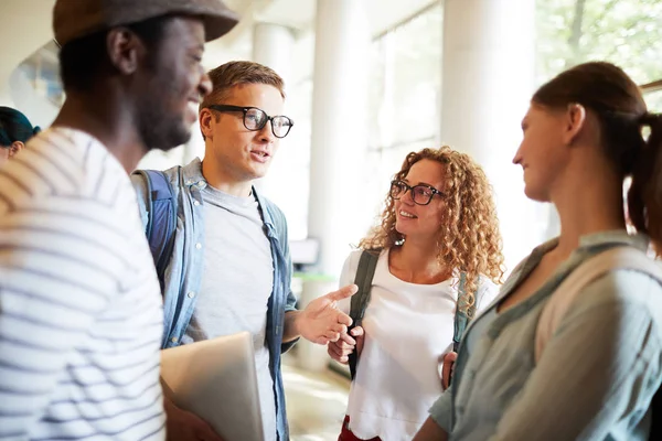 Group of young intercultural college friends discussing where to go after lessons