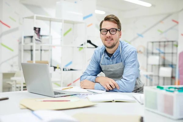 Feliz Joven Diseñador Moda Guapo Delantal Apoyado Mesa Con Ordenador — Foto de Stock