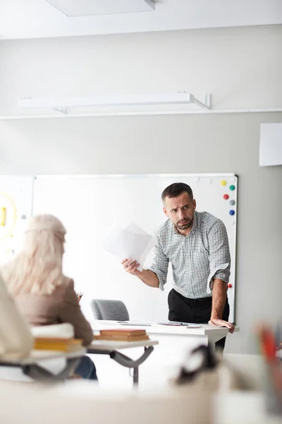 Profesor Serio Reflexivo Con Papeles Inclinados Sobre Lugar Trabajo Frente — Foto de Stock