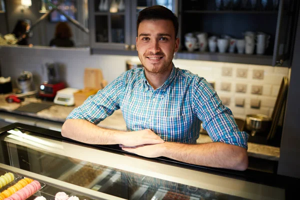 Jonge Verkoper Zoek Naar Camera Terwijl Leunen Door Grote Display — Stockfoto