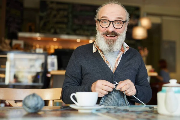 ドリンク カフェでくつろぎながらウール Winterwear を編む幸せの年配の男性 — ストック写真