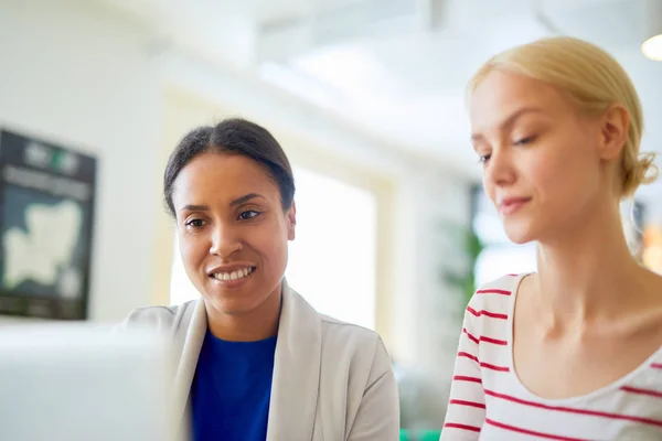 Två Interkulturell Kvinnliga Anställda Tittar Laptop Display Medan Läser Online — Stockfoto