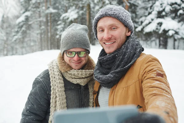 Şapka Eşarplar Kış Ormanda Ayakta Akıllı Telefon Üzerinde Otoportre Yapma — Stok fotoğraf