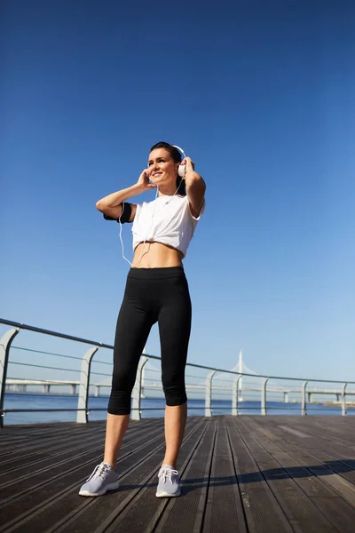 Alegre Confiante Atraente Jovem Jogger Feminino Ajustando Fones Ouvido Com — Fotografia de Stock