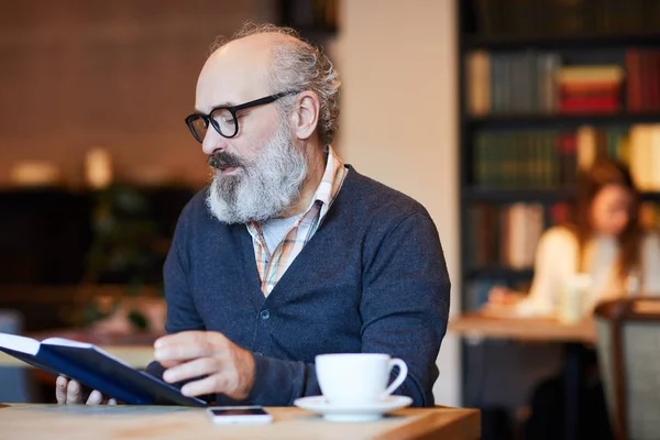 Äldre Man Med Skägg Läsa Bok Eller Hans Anteckningar Anteckningar — Stockfoto