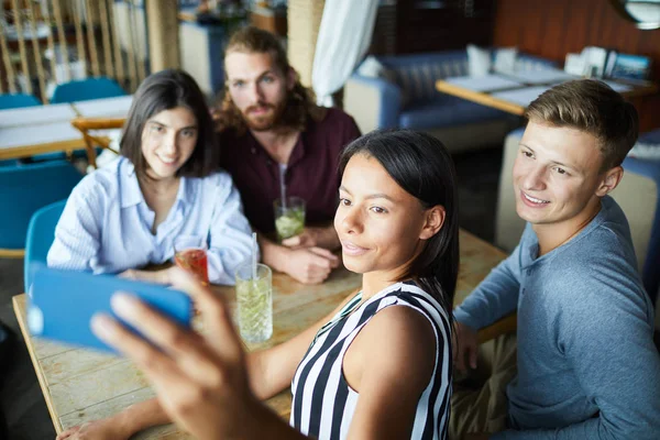 Grupo Cuatro Jóvenes Amigos Haciendo Selfie Mientras Están Sentados Mesa —  Fotos de Stock