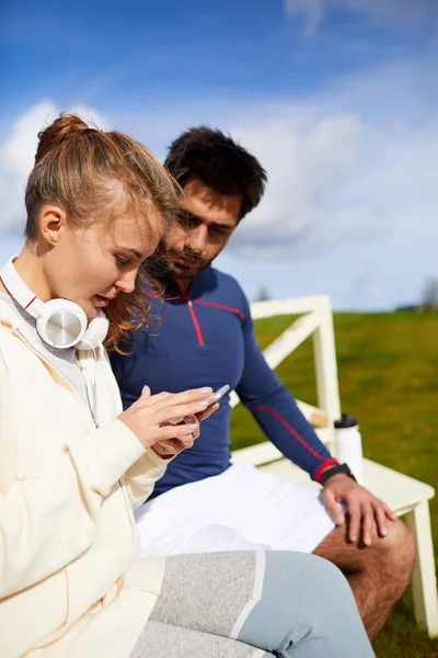 Young Active Woman Scrolling Her Smartphone While Sitting Next Her — Stock Photo, Image