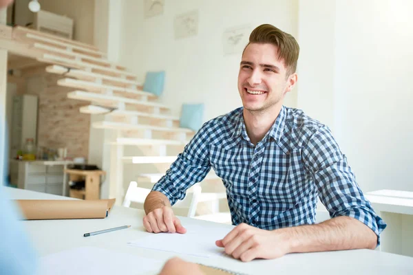 Młody Śmiejący Się Biznesmen Luźnej Koszuli Siedzący Studio Przed Kolegą — Zdjęcie stockowe