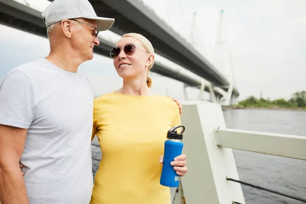 Senior Man Och Kvinna Som Omfamnar Medan Promenader Längs Riverside — Stockfoto