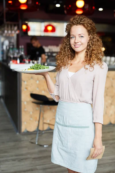 Щаслива Красива Молода Офіціантка Червоним Кучерявим Волоссям Тримає Тарілку Їжі — стокове фото