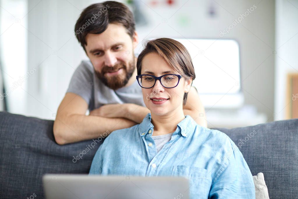 Young couple searching for hot offers in the net while going to spend their vacation abroad