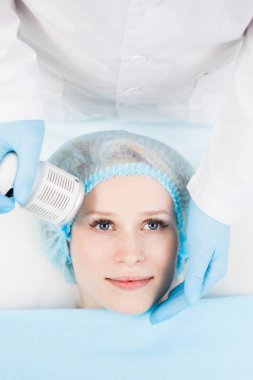 Güzellik salonunda elektrikli aletlerle masaj yaptıran genç bir kadın.