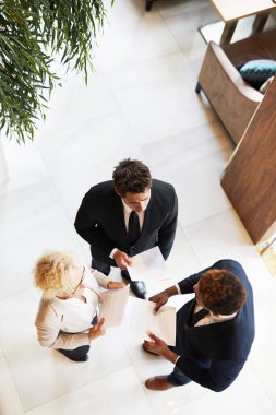 Raporlarla ayakta duran ve iş sunumuna hazırlanmaya hazırlanan iş ekibinin yüksek açılı görünümü