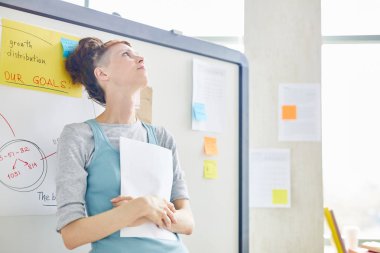 Ders veya seminerden önce sınıfta beyaz tahtaya yaslanmış gündelik giyimli sinirli öğrenci