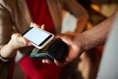 Restoran 'ın genç müşterisi akıllı telefon ve elektronik ödeme terminali aracılığıyla ulaşılamaz ödeme yapıyor.